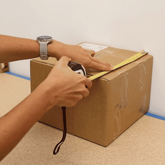 box on a wall and being measured
